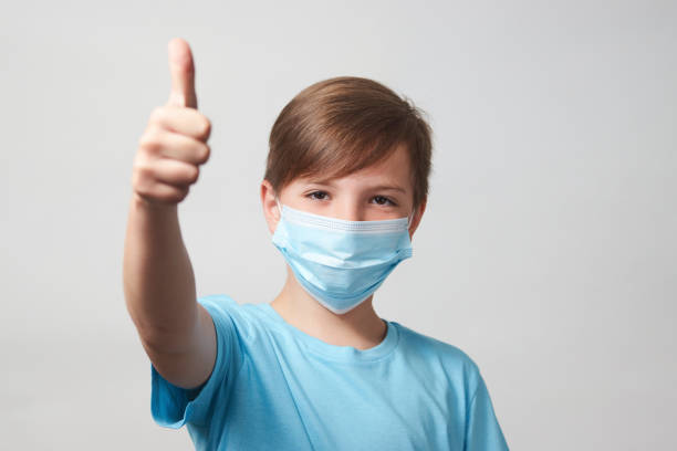 istock School boy with face mask on white background 1320802813