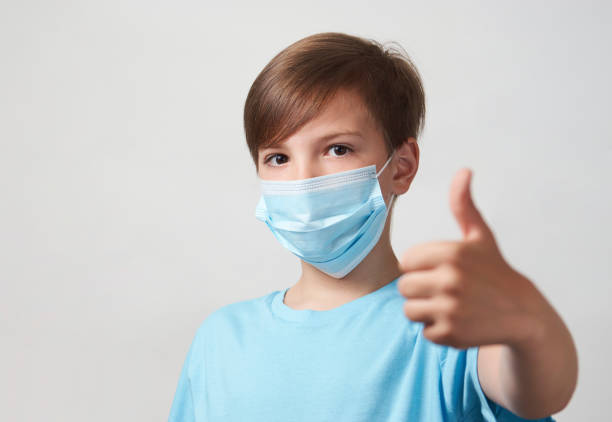 istock School boy with face mask on white background 1320802824