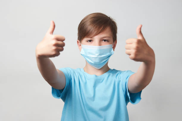 istock School boy with face mask on white background 1320802834