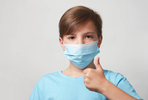 istock School boy with face mask on white background 1320802846