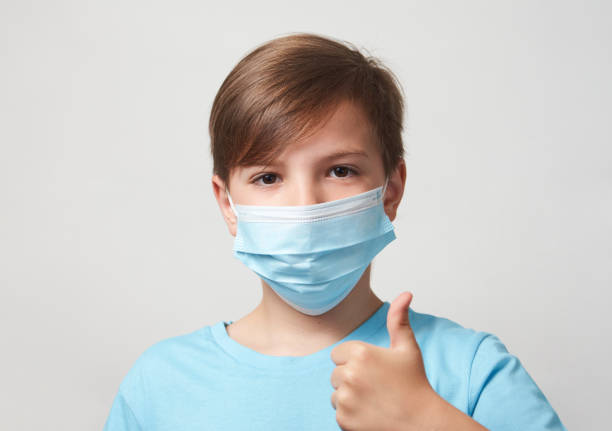 istock School boy with face mask on white background 1320802851
