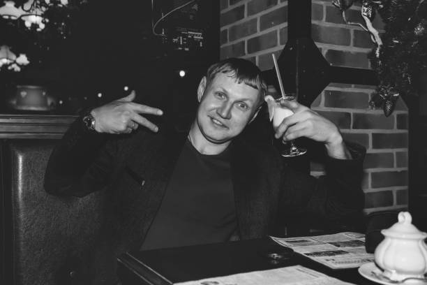 istock Handsome young man drinking cocktail in night bar at table 1320806146