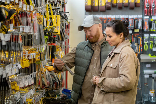 pareja de mediana edad eligiendo handtools en el supermercado de ferretería - ferretería fotografías e imágenes de stock