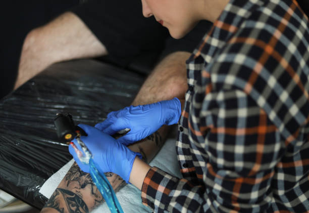 istock Tattoo artists doing a Tattoo 1320808216