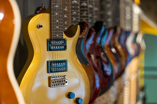 Row of electric guitars different color in a music instruments shop close up