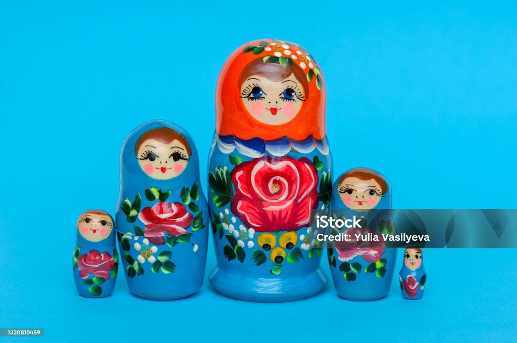 Russian wooden doll matryoshka on blue background Matryoshka russian wooden toy souvenir, stacking toy Russian Nesting Doll Stock Photo