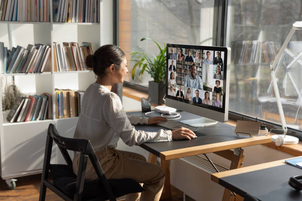 Indian businesswoman involved in internet meeting with colleagues, video call Rear view Indian businesswoman involved in internet meeting with colleagues, group video call, diverse businesspeople employees negotiating, discussing project strategy, using webcam and computer remote location stock pictures, royalty-free photos & images