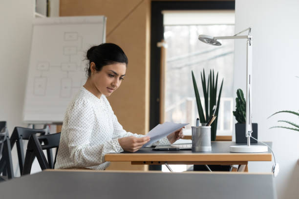 istock Focused Indian businesswoman using laptop, reading checking financial documents 1320811441