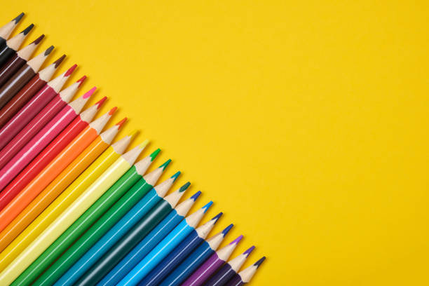 istock colored pencils lined up diagonally on a yellow background 1320811768