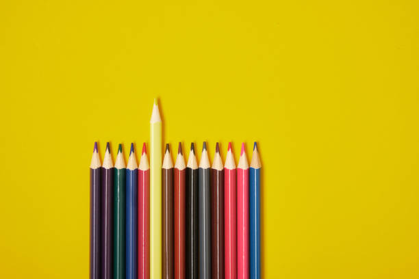 istock color pencils on yellow background top view 1320811777