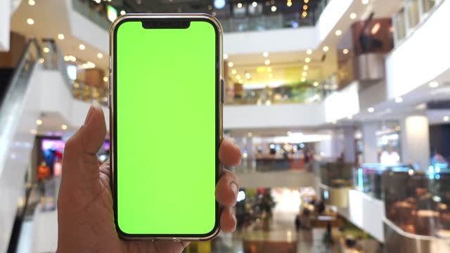 Smartphone with green screen at shopping mall