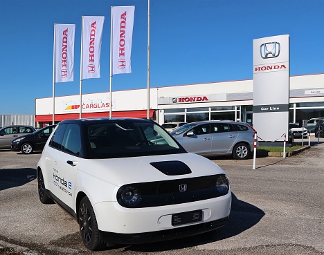 Tavagnacco, Italy. May 30, 2021. New Honda E, small  electric car, outside the dealer Car Line of the japanese automaker. Carglass store on its left.