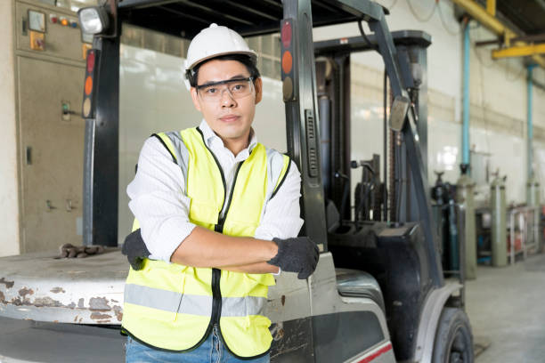 istock Foreman or technician standing with a forklift parked in the factory. 1320816970