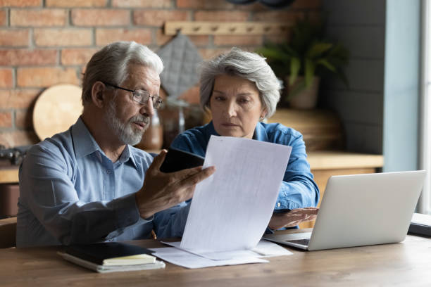 istock Focused worried older spouses reading financial documents checking bills 1320817140