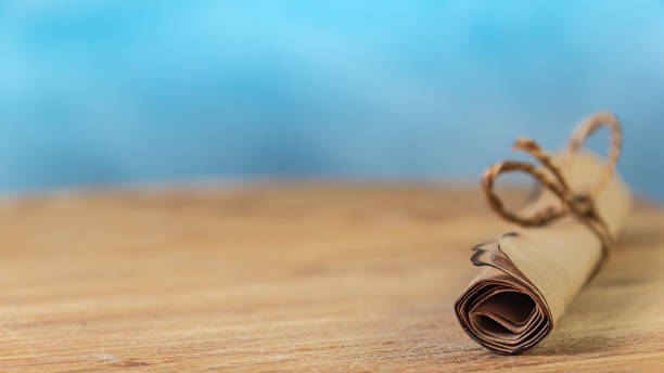 istock Parchment scroll on wooden table is tied with rope 1320817346