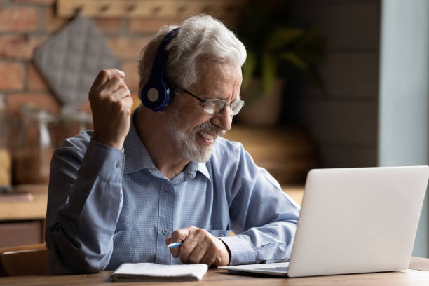 hombre maduro usar portátil obtener nuevos conocimientos utilizar recursos de internet - digital enhancement audio fotografías e imágenes de stock