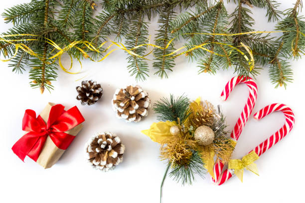 istock Festive gift box with spruce branches, caramel staves and pinecone on a white background. 1320820917
