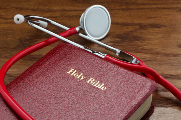 Medicine and faith symbolized in Bible and stethoscope stock photo