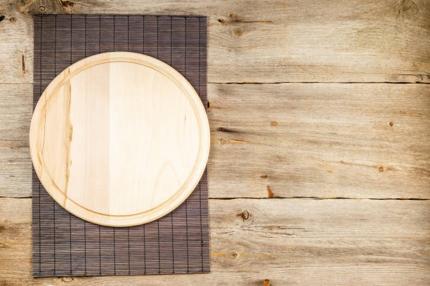istock Wooden pizza board over grunge rustic background 1320828011