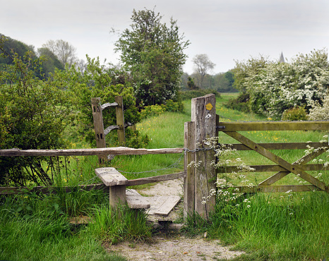 Long metal field gate on a countryside track, with views over distant fields