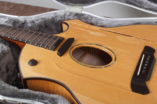 Musical instrument - Closeup fragment Broken acoustic guitar in hard case