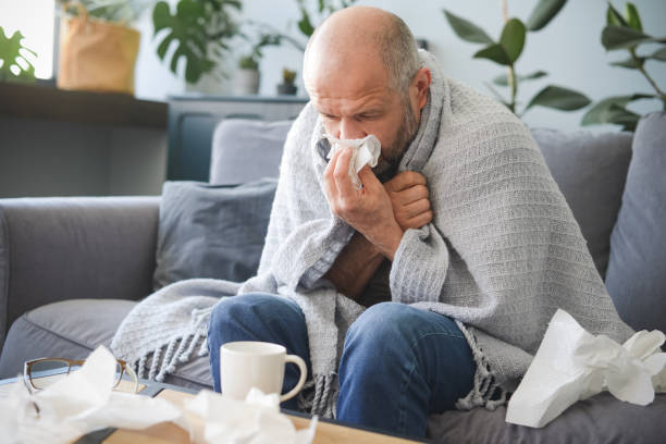 istock sick man sitting on a sofa in the room 1320837125