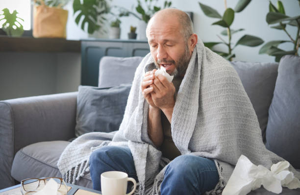 istock sick man sitting on a sofa in the room 1320837874