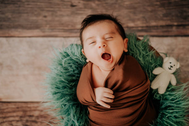 istock Little baby boy in a knitted hat in a basket, napping happily 1320837896