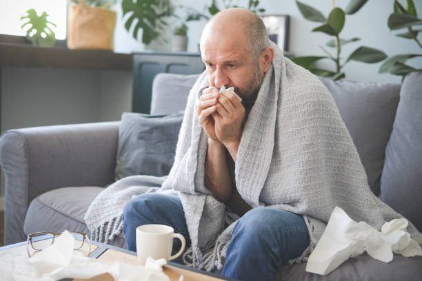 istock sick man sitting on a sofa in the room 1320837913
