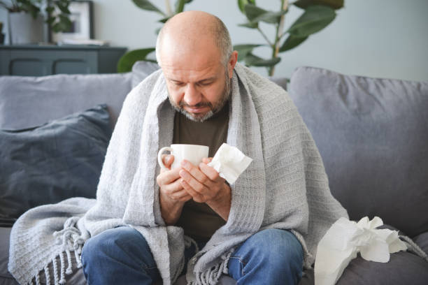 istock sick man sitting on a sofa in the room 1320837992