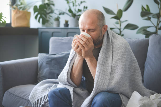 istock sick man sitting on a sofa in the room 1320838159