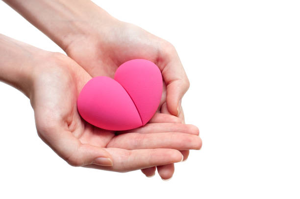 istock Two pink makeup sponges in hands on a white background 1320838182