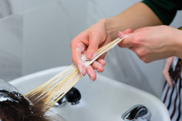 Washing hair dye from a hairdresser, removing foil from hair. Washing hair dye from a hairdresser, removing foil from hair. new comb over stock pictures, royalty-free photos & images