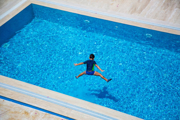 istock Hello Summer Holiday, Little Boy Jumping into the Swimming Pool 1320840029