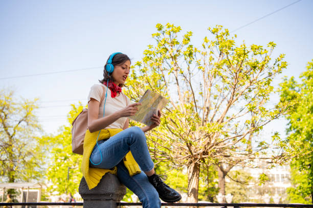 istock Female tourist with map visiting city and looking around 1320841225