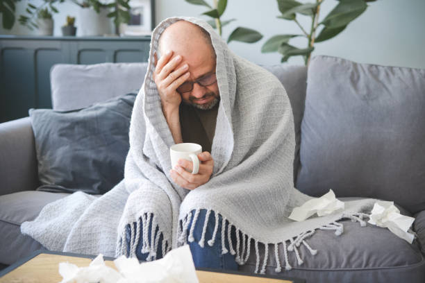 istock sick man sitting on a sofa in the room 1320841236