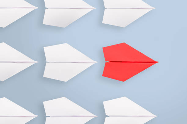 istock Change concepts with red paper airplane leading among white 1320841857