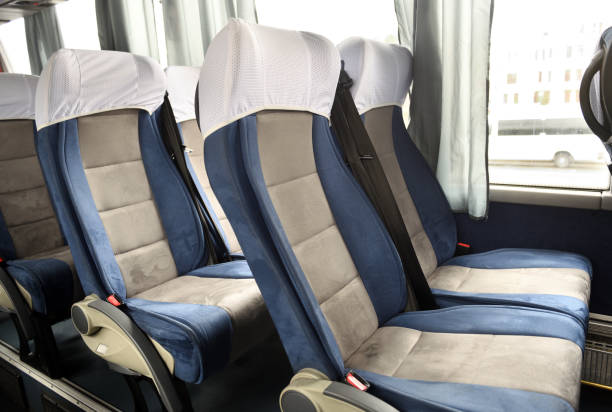 istock Comfortable bus seats backs without passengers, Intercity coach services, New bus interior with seat belts on each place.Passenger bus interior with empty seats. 1320841880