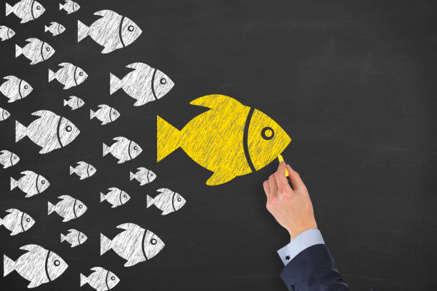 istock Leadership Concepts with Fishes on Chalkboard Background 1320841982