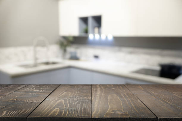 istock Empty wooden tabletop and defocused modern kitchen as background for design. 1320842467