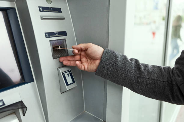 istock Businessman using card at an ATM 1320843625