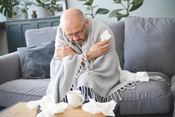 istock sick man sitting on a sofa in the room 1320843632