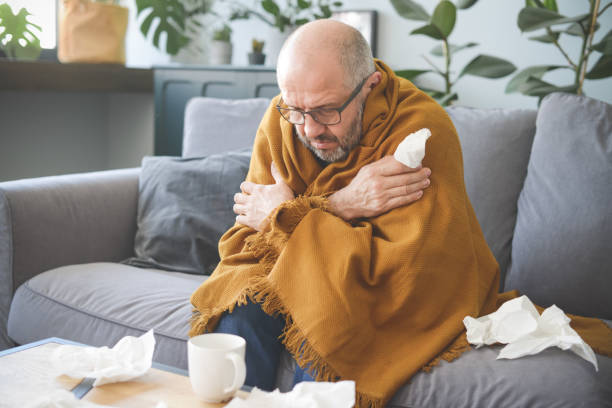 istock sick man sitting on a sofa in the room 1320844270