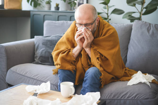 istock sick man sitting on a sofa in the room 1320844364
