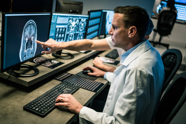istock Colleagues discussing MRI scan displayed on computer monitor. 1320844608