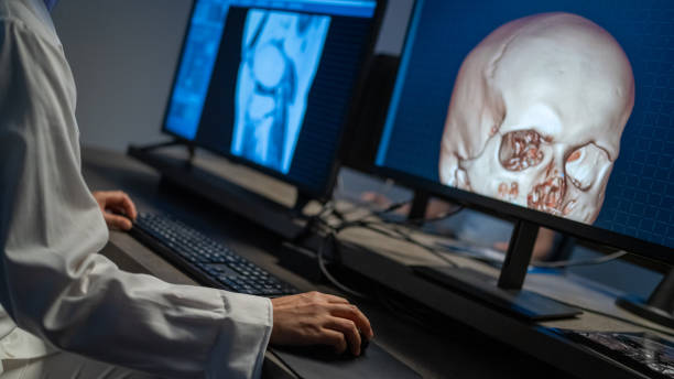 istock Cropped view of doctor working on computer, displaying 3D model of skull on screen. 1320844616