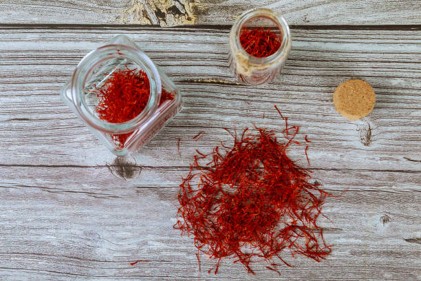 istock Dry organic red saffron spice in jar on wood background 1320851366