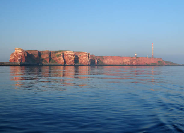 view from the sea to the rusty cliffs and the famous sea stack lange anna of the north sea island helgoland - granite travel audio imagens e fotografias de stock