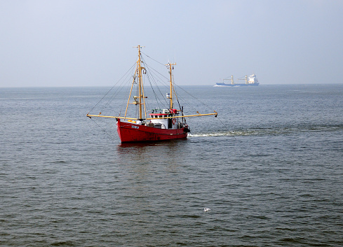 Small Red Fish Trawler Fishing In The North Sea On A Hazy And Sunny Summer Day