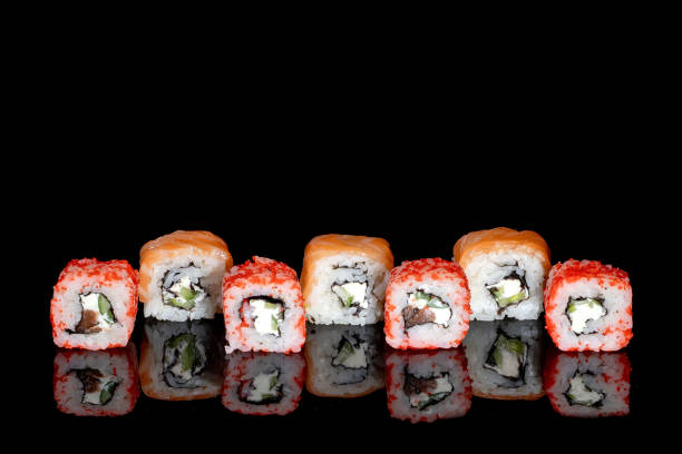 istock Philadelphia roll with salmon, cheese and cucumber on a black background with reflection. Sushi Philadelphia 1320857391